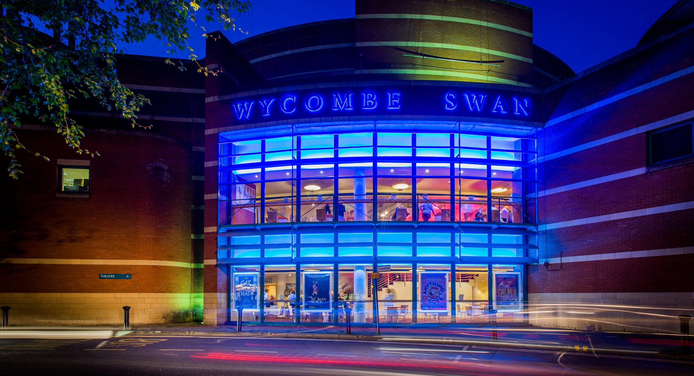 Red brick exterior image of the Wycombe Swan building with blue lights on the windows.